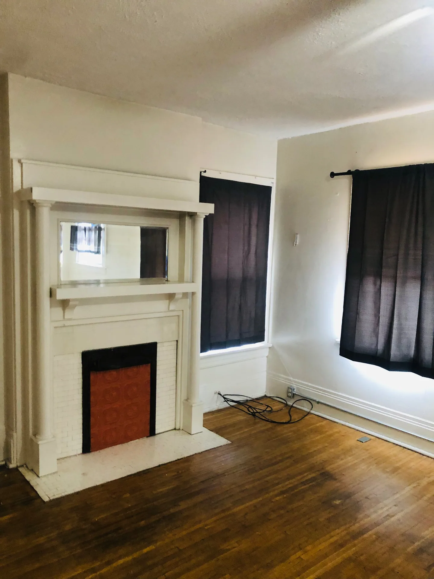 2005 Summit St. living room with white Craftsman mantel, built-in mirror, and hardwood floors