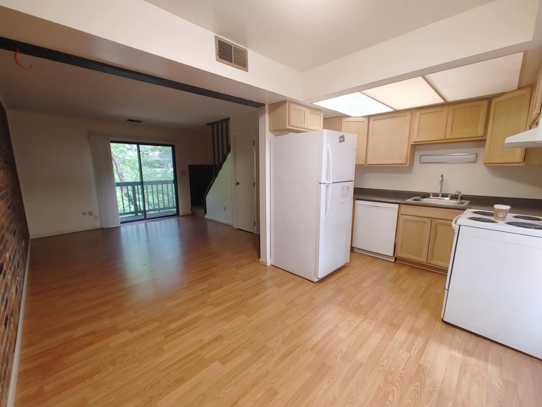 2020 Iuka Ave. open kitchen and living area with sliding doors to a balcony overlooking greenery