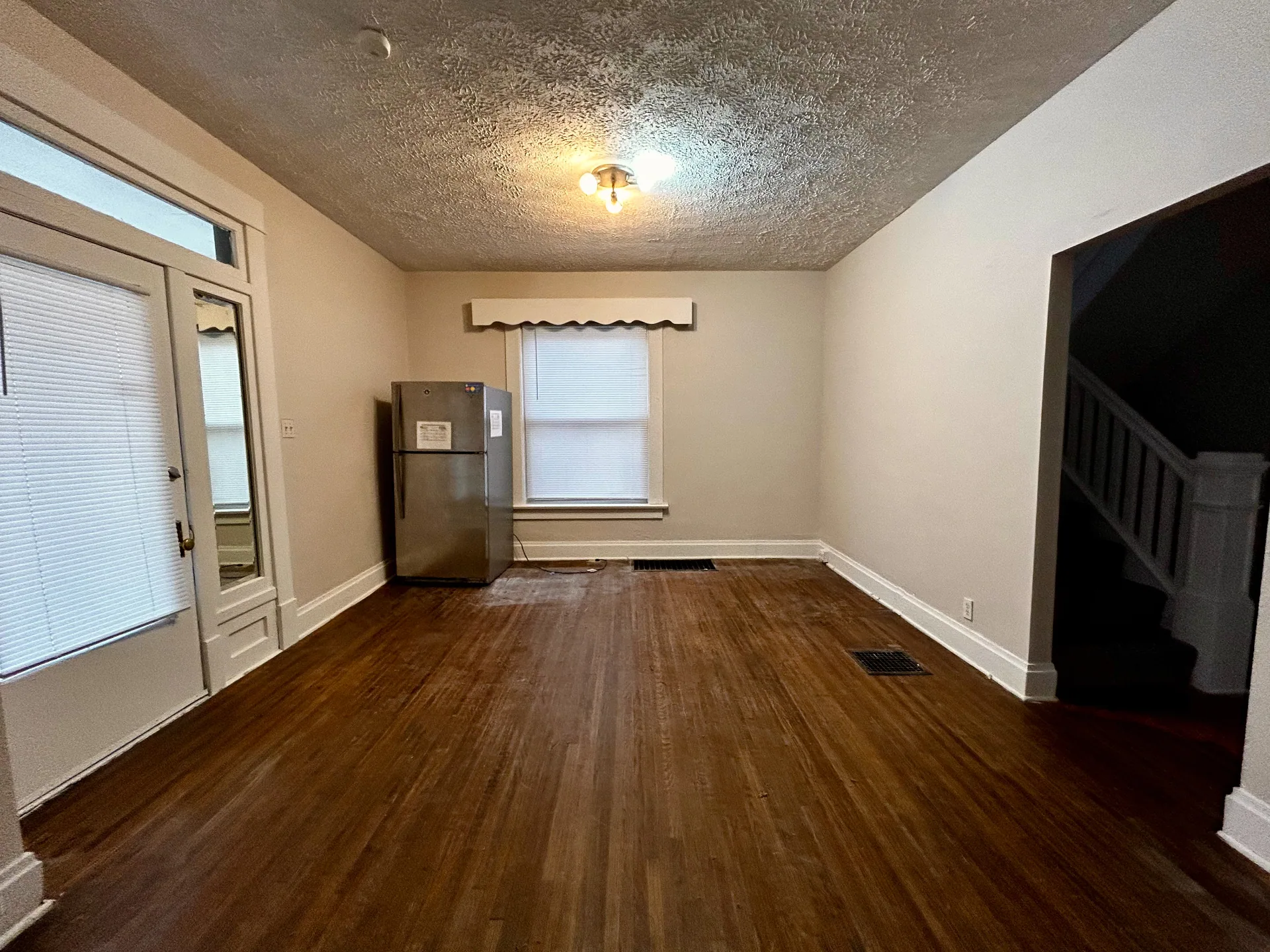 68 E Patterson Ave. dining area with refinished hardwood floors, stainless fridge, and staircase to upstairs