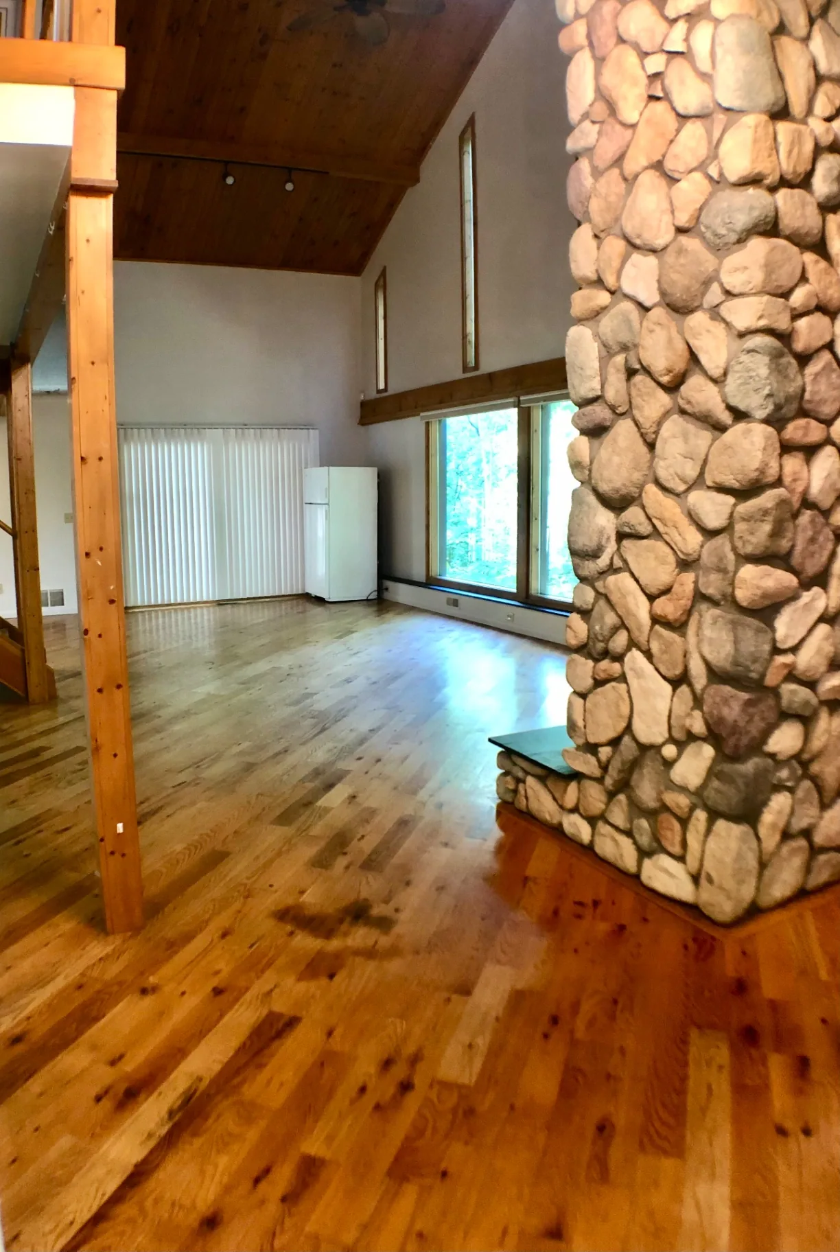 2040 Iuka Ave House great room with soaring vaulted ceiling, river-stone fireplace, and hardwood floors